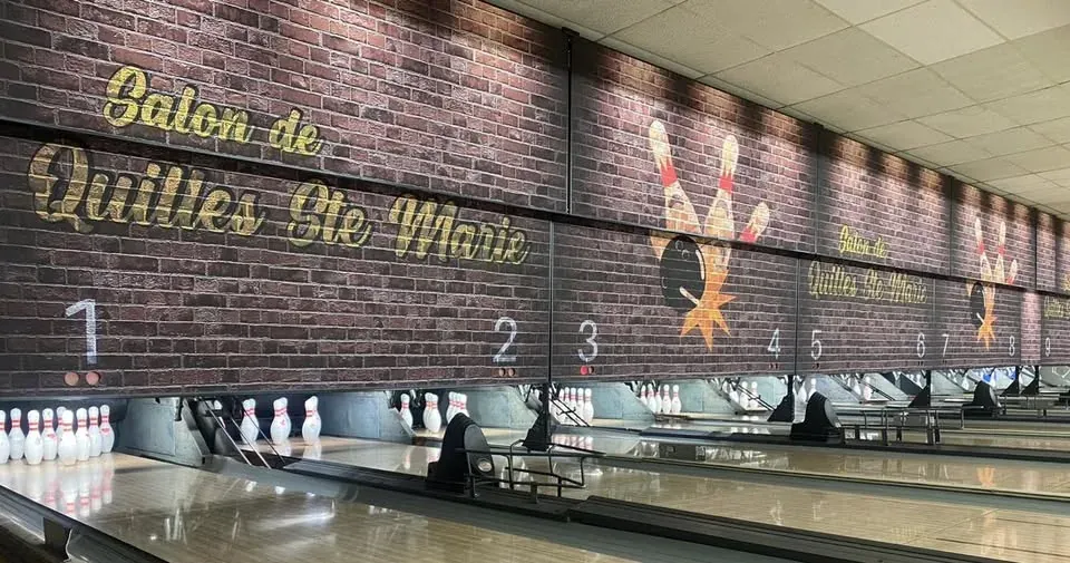 Mur de brique peint aux couleurs du Salon de Quilles Ste-Marie, au bout des allées de petites quilles